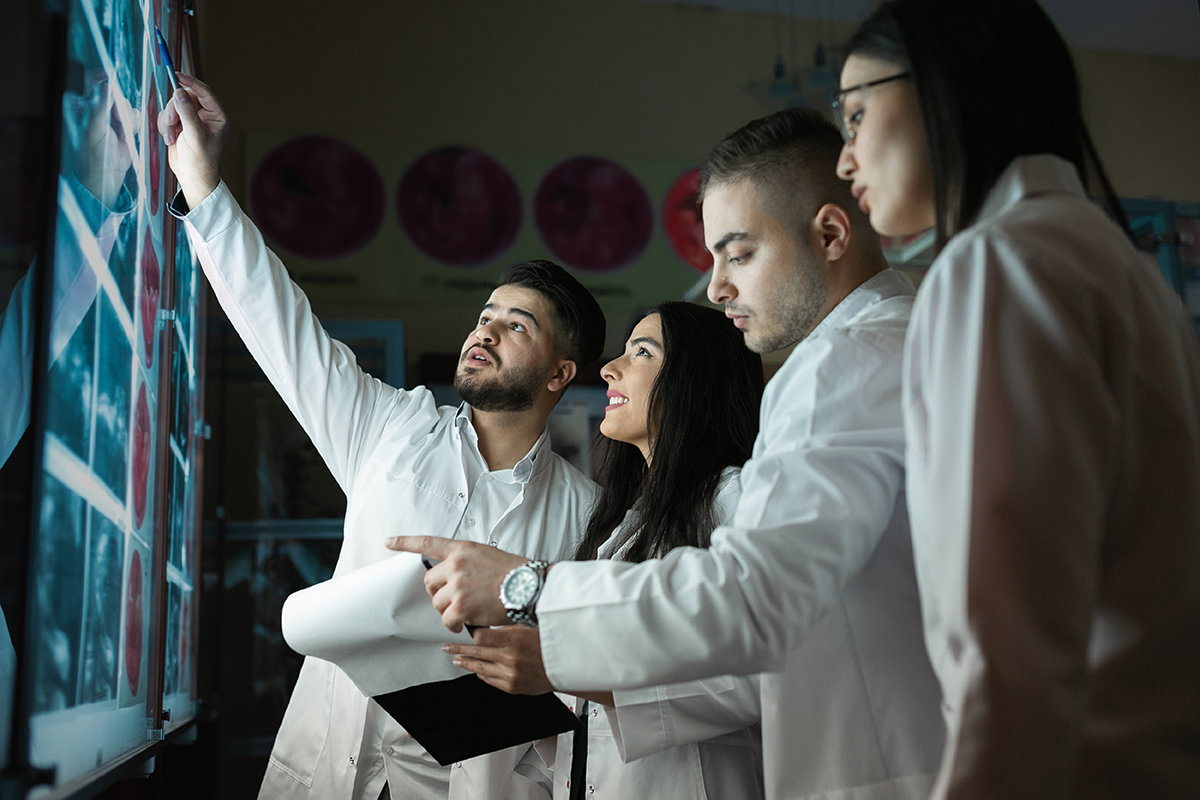 Four health professionals looking at x-rays